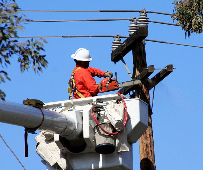 Image of a utility worker fixing a power line.
